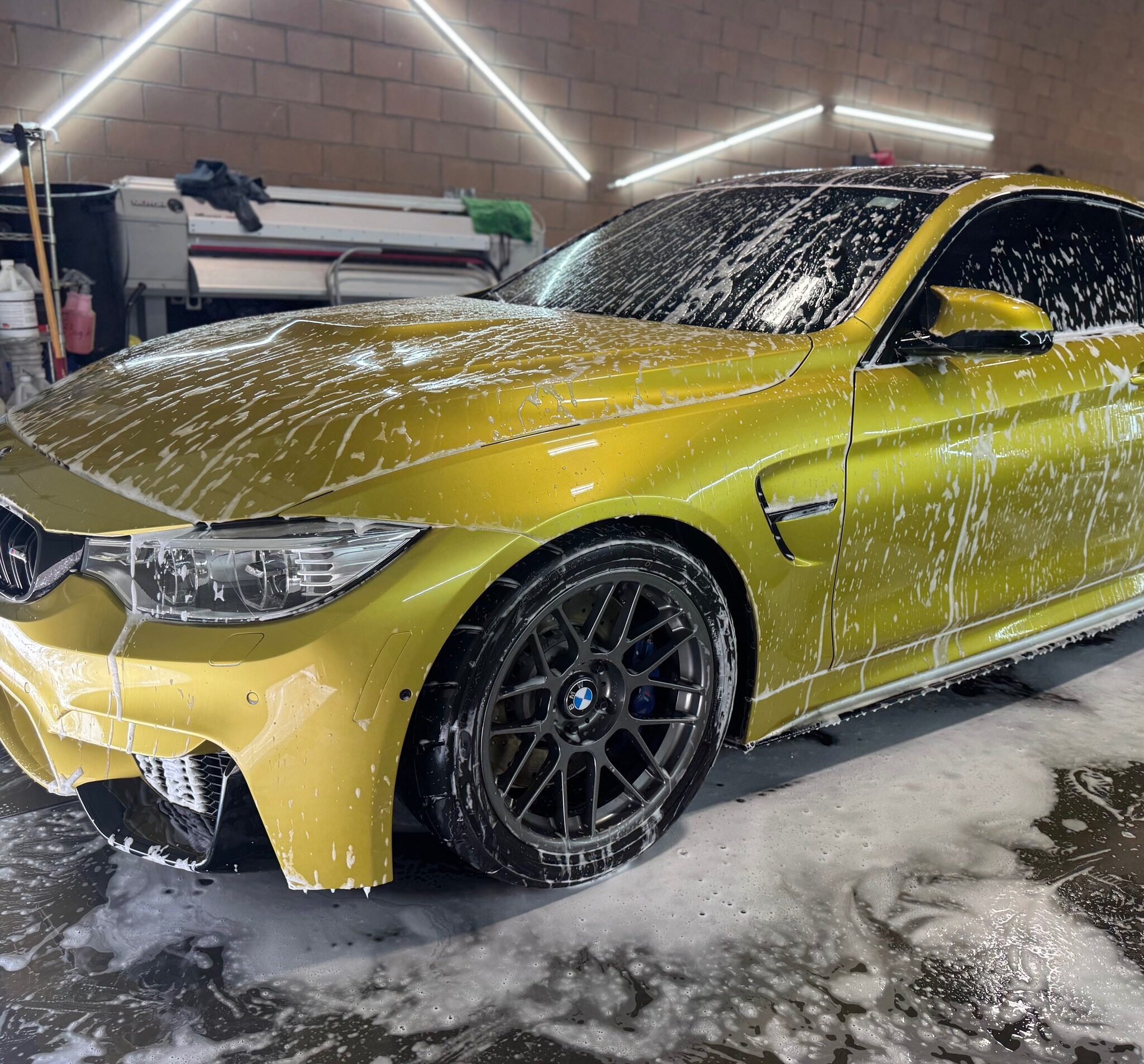 BMW M4 sports car covered in foam during an auto detailing service at Luxe Auto Salon, showcasing premium vehicle care and cleaning techniques.