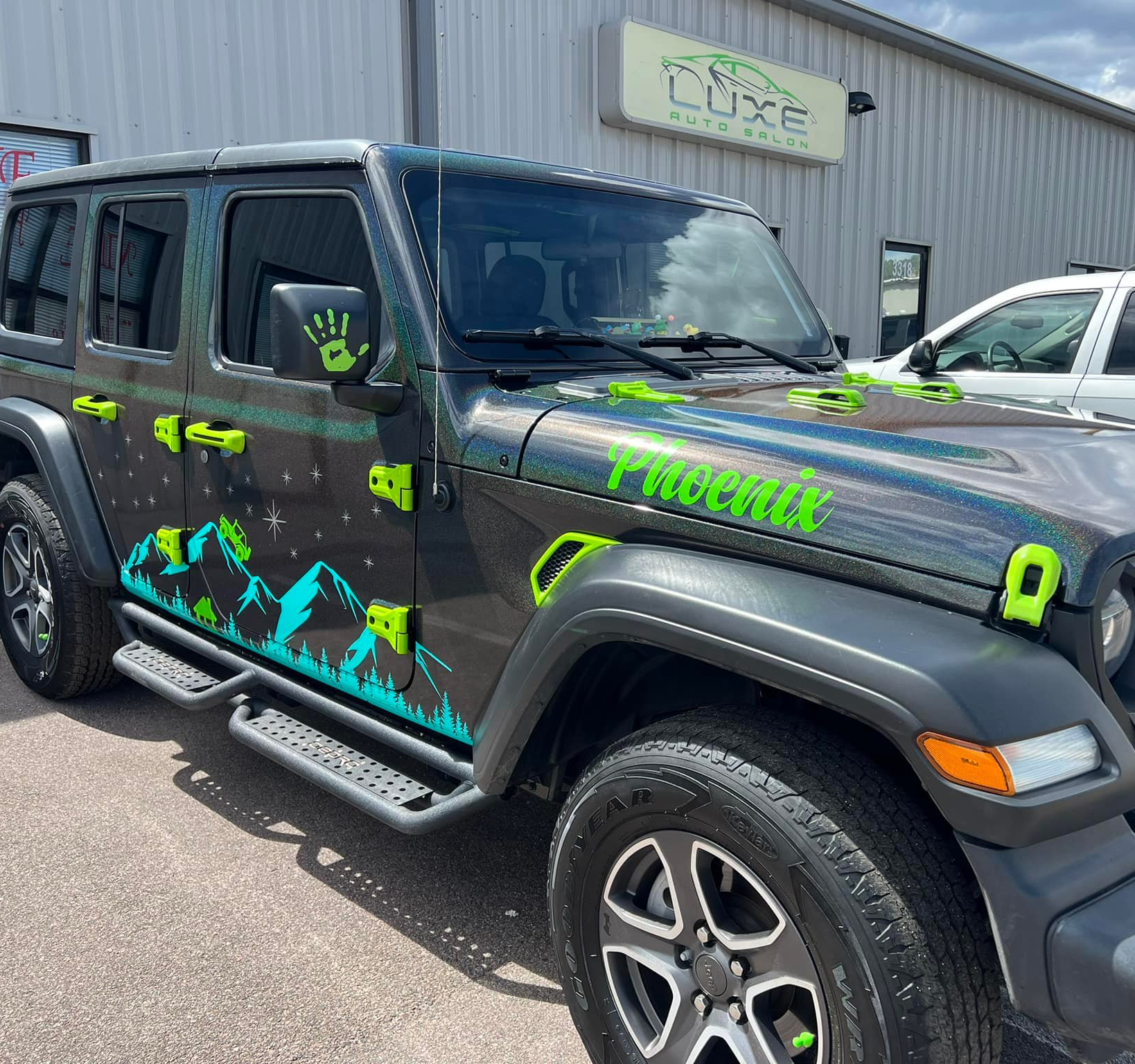 Jeep with custom vinyl wrap featuring vibrant green accents and mountain graphics, showcasing Luxe Auto Salon's expert styling and accessory installation services.