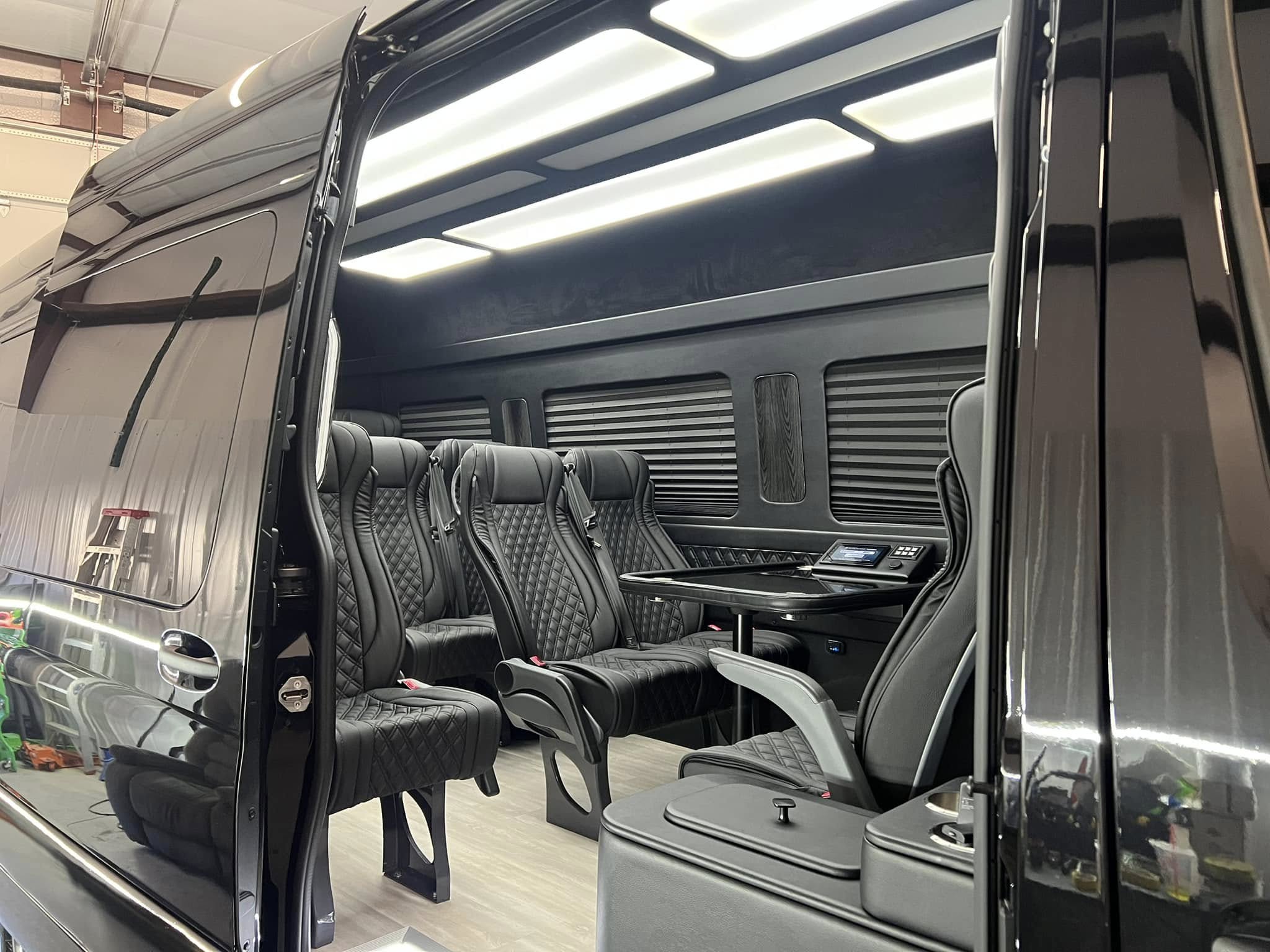 Luxurious black interior of a van featuring plush, quilted seating, ambient lighting, and a sleek design, showcasing the high-quality auto detailing services offered by Luxe Auto Salon.