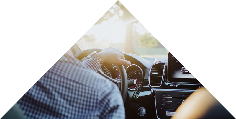 Person driving a car with a focus on the dashboard and modern infotainment system, highlighting the luxury experience associated with Luxe Auto Salon's auto detailing and customization services.